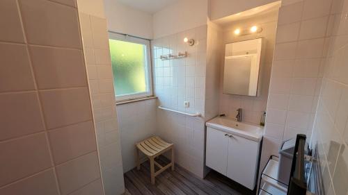 une salle de bain blanche avec un lavabo et un miroir dans l'établissement Bilboquet, à Vals-les-Bains