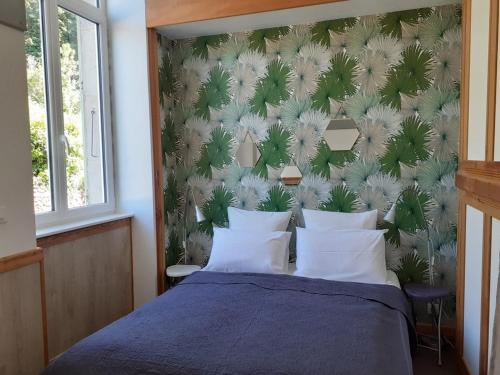 - une chambre dotée d'un lit bleu avec un mur vert et blanc dans l'établissement Bilboquet, à Vals-les-Bains