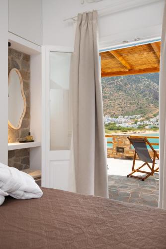 Un dormitorio con una cama y una ventana con una silla. en Grand View, en Kamarai