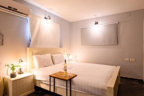 a bedroom with a bed and a table with wine glasses on it at בקתות ילוז של רשת לב הגולן - 6 צימרים מקסימים עם בריכה משותפת ליד הכנרת in Yavneʼel