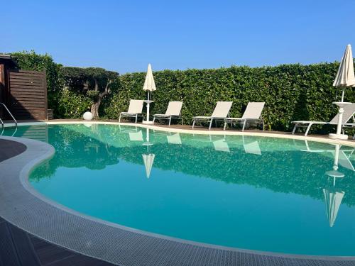 a large swimming pool with chairs and umbrellas at B&B Artemide in Agropoli