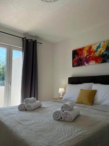 a bedroom with towels on a bed with a window at Apartmani Šegota in Lun