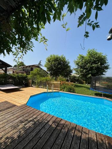 - une piscine bleue sur une terrasse en bois dans l'établissement Le Chai du Père Igord - 20 personnes, à Monestier