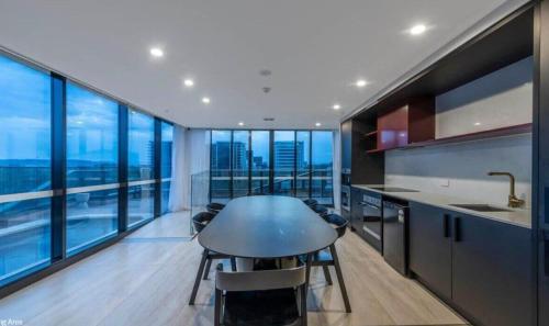 a kitchen with a table and some chairs and windows at 2B-1BR-1Car-Courtyard-CBD-Shops in Canberra