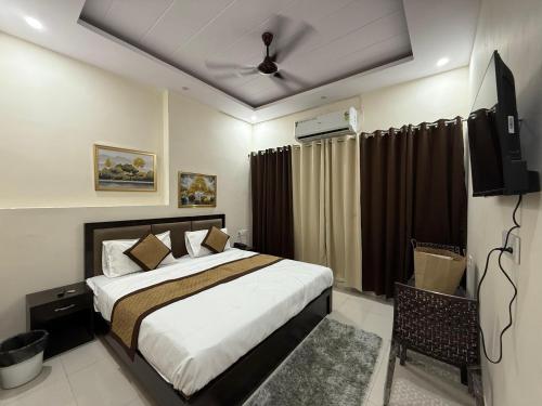 a bedroom with a bed and a flat screen tv at Hotel Pear in Haldwāni