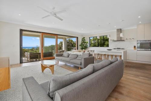 un grand salon avec un canapé et une cuisine dans l'établissement ULTIMATE NOOSA Six Bedroom Luxury with WATERSLIDE!, à Sunrise Beach