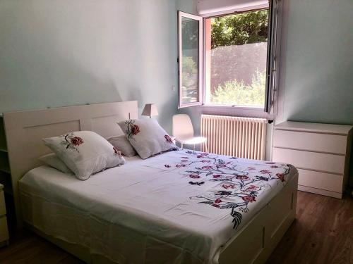 une chambre avec un lit avec des draps blancs et une fenêtre dans l'établissement Villa Mina, à Meyrannes