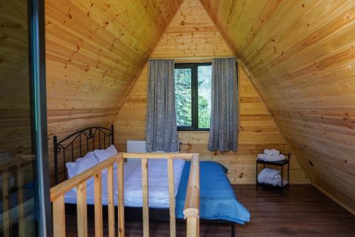 une chambre dans une cabane en rondins avec un lit dans l'établissement Kokhta Cottage Kazbegi, à Kazbegi