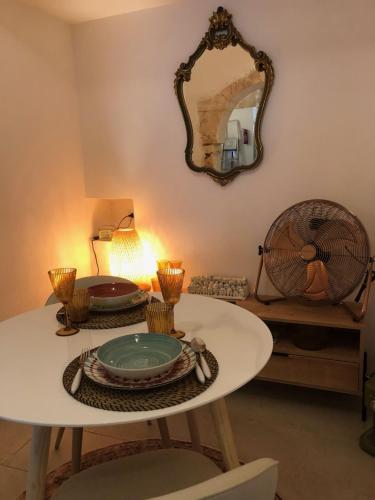 a white table with a mirror on the wall at Alcova'800 in Ostuni
