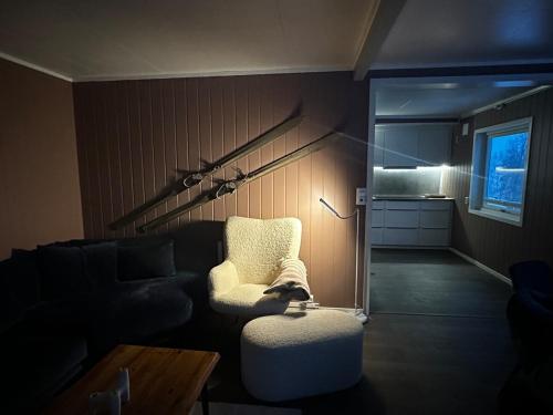a living room with a chair and a couch at Lyngen Blue House in Lyngseidet