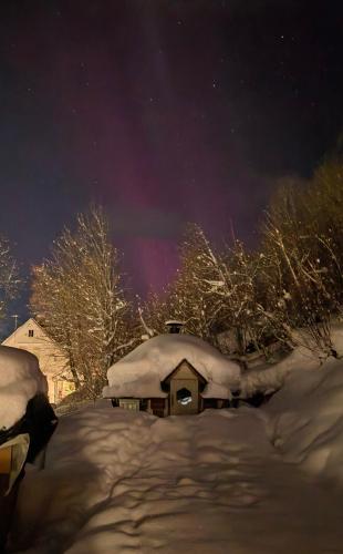 a house covered in snow under a night sky at Lyngen Blue House in Lyngseidet