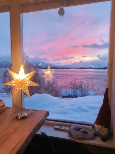 a window with a view of a winter sunset at Lyngen Blue House in Lyngseidet