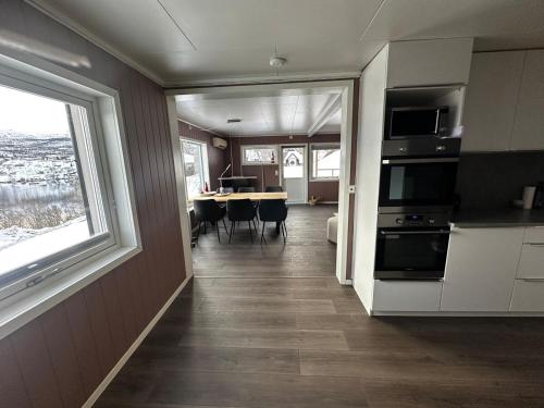 a kitchen and dining room with a table and a window at Lyngen Blue House in Lyngseidet