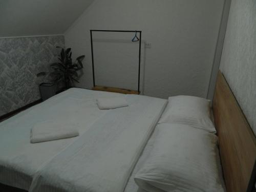 a bed with two pillows on it in a room at Arashan Guest house in Teploklyuchinskoye
