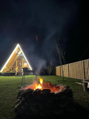 a fire pit in front of a house at night at Kolsay Aframe Vibes in Saty