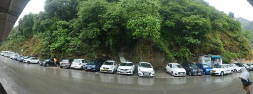 a row of cars parked on the side of a mountain at Sheetal Restaurant in Mussoorie
