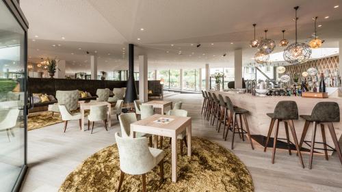 a restaurant with a bar with chairs and a counter at Hotel Schwefelbad (Schenna Resort) in Schenna