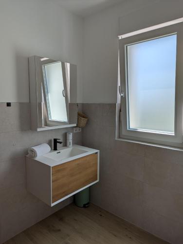 a bathroom with a sink and a window at Apartments Good Times with heated pool in Kaštela