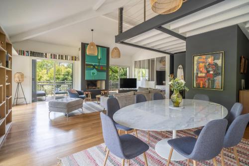 un salon avec une table et des chaises dans l'établissement Villa les Chênes l Piscine chauffée l Climatisation l Plage l Dune du Pyla, à La Teste-de-Buch