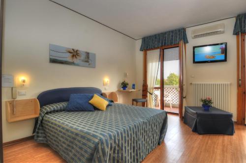 a bedroom with a bed and a television on the wall at Al Cavallino Bianco in Lignano Sabbiadoro
