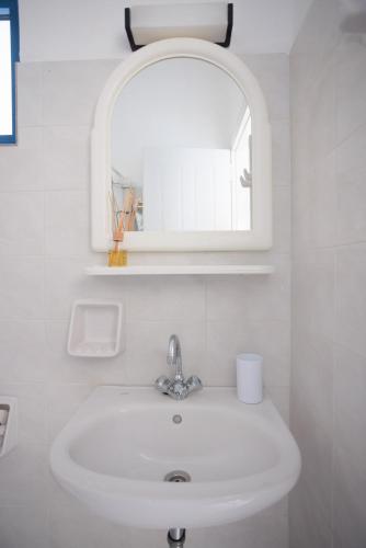 a white sink in a bathroom with a mirror at Aurea Blu Studio 06, sun, beach, sea, relaxation in Aliko Beach