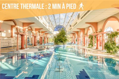 - une grande piscine dans un bâtiment avec des personnes dans l'établissement L'Aurore - Terrasse - Duplex - Parking, à Dax