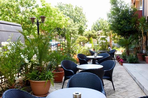 an outdoor patio with tables and chairs and plants at Guesthouse Kirov in Ravda