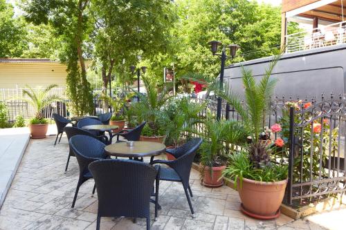 a patio with tables and chairs and potted plants at Guesthouse Kirov in Ravda