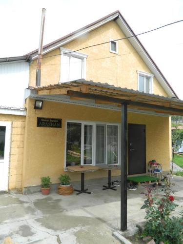 a yellow house with a large window on it at Arashan Guest house in Teploklyuchinskoye