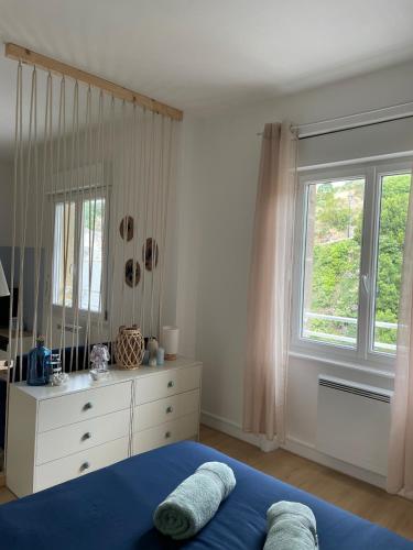 une chambre avec un lit, une commode et une fenêtre dans l'établissement Appartement Port la Houle avec Parking privé à 5min à pied, à Cancale