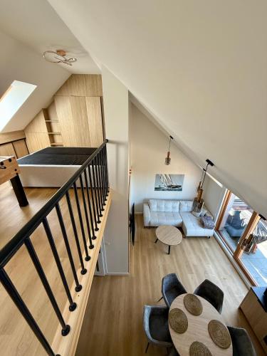 a room with a staircase and a living room at Czyżyk - Apartamenty Rydzewo in Rydzewo