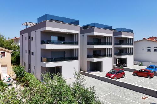 an apartment building with a red car parked in a parking lot at K2-Penthouse with sea view and heated pool in Vir