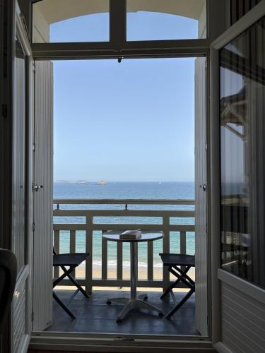 a balcony with a table and a view of the ocean at Studio Rêve de mer vue mer in Dinard