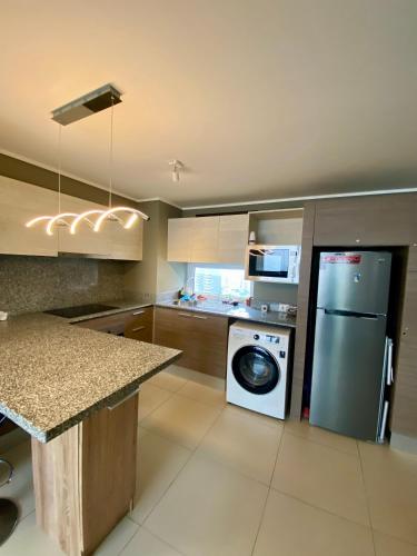 a kitchen with a washing machine and a washer and dryer at Gran Vista al Mar Moderno Depto Costa Montemar in Concón