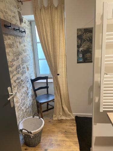 Cette chambre dispose d'une porte avec une chaise et une fenêtre. dans l'établissement Maison de charme 7 personnes, à Montvalent