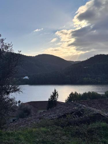 a view of a lake with a house and mountains at New Flat with View over the River Zezere in Casalinho de Santana