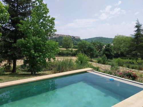 une piscine avec vue sur un jardin et des arbres dans l'établissement Le Pré de la Reyne, à Sault