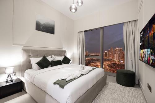 a bedroom with a large white bed with a large window at SkyHigh 2BR Burj Views Steps to Dubai Mall in Dubai
