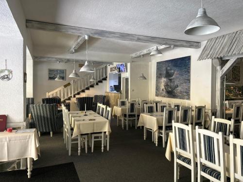 a dining room with white tables and chairs at Brasserka in Nitra