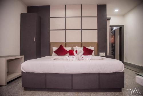 a bedroom with a large bed with red pillows at Hotel La Vista Inn in Tinsukia