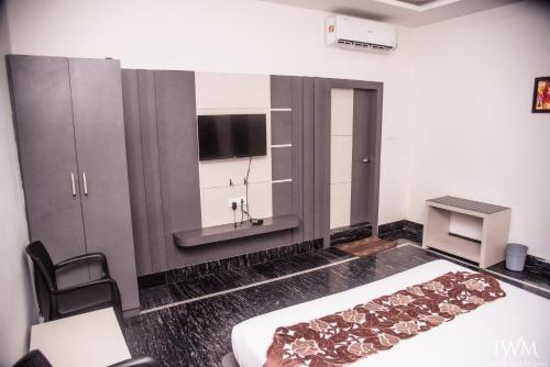 a bedroom with a bed and a tv in it at Hotel La Vista Inn in Tinsukia