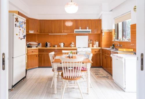 a kitchen with wooden cabinets and a table and chairs at Zina's Aqua Retreat - Kos in Ampavris