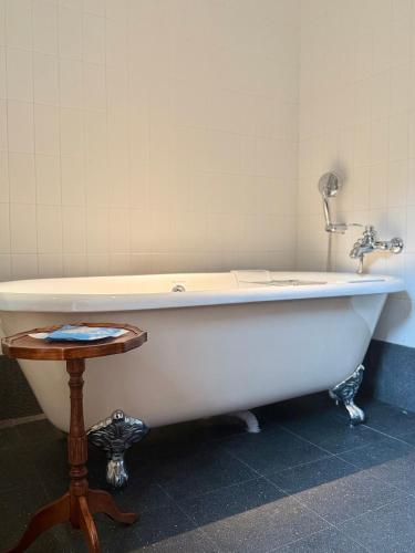 - une baignoire blanche dans une chambre avec une table dans l'établissement Xiamen Gulangyu Bishan Residence, à Xiamen