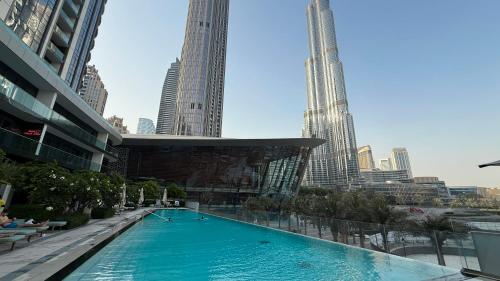 a large swimming pool in a city with tall buildings at SkyHigh 2BR Burj Views Steps to Dubai Mall in Dubai