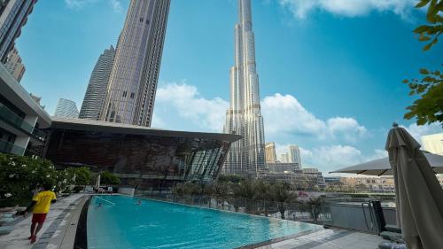 a swimming pool in a city with tall buildings at SkyHigh 2BR Burj Views Steps to Dubai Mall in Dubai