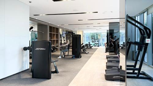 a gym with a row of treadmills and people exercising at SkyHigh 2BR Burj Views Steps to Dubai Mall in Dubai
