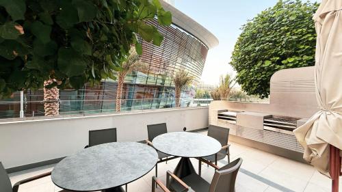 two tables and chairs on the balcony of a building at SkyHigh 2BR Burj Views Steps to Dubai Mall in Dubai