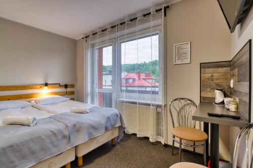 a bedroom with a bed and a large window at Ada in Muszyna
