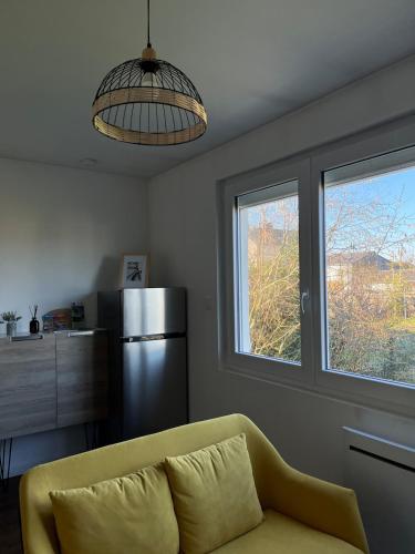 - un salon avec un canapé jaune et un réfrigérateur dans l'établissement Cozy garden house, à Châteaubriant