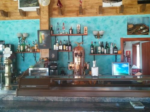 a bar in a room with bottles on the wall at Apartamentos Paraje San Gines in Andújar